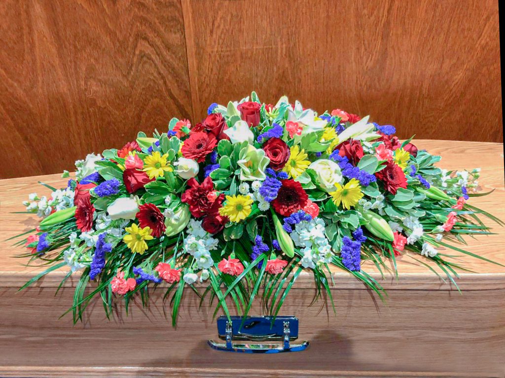 Vibrant Bright Coffin Arrangement in Reds Purples, Oranges and Yellows
